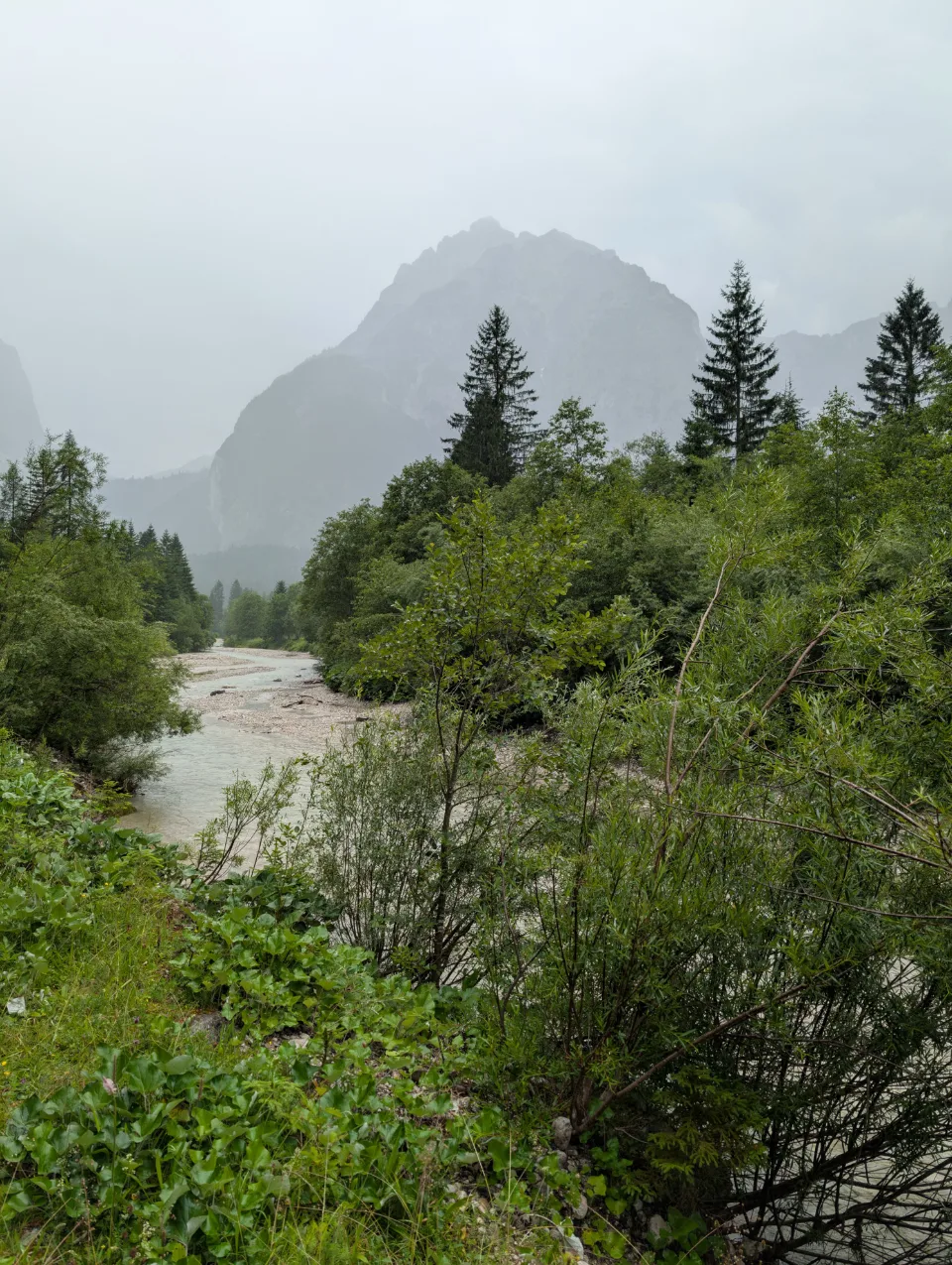 A rushing stream through hazy mountains