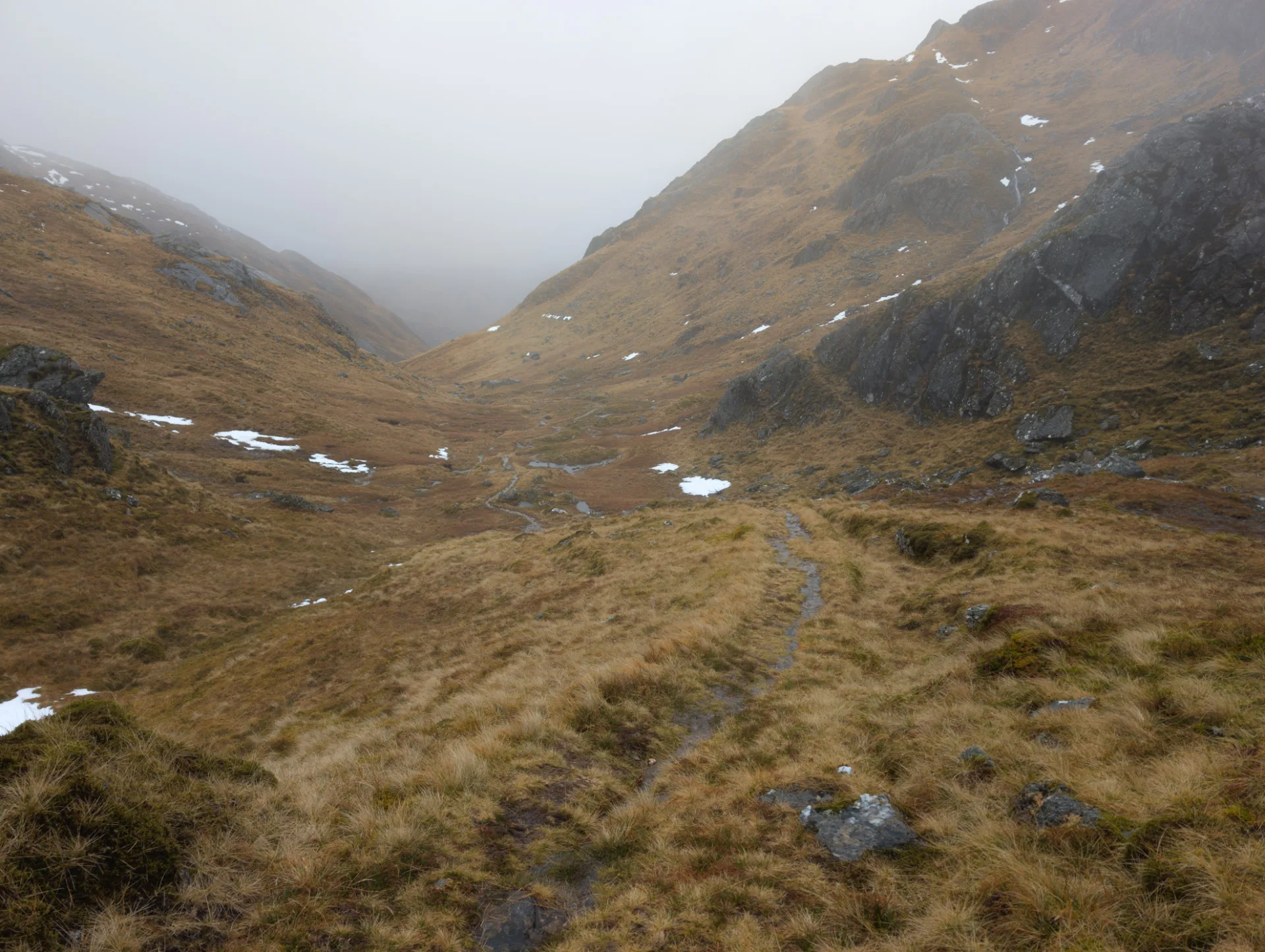 On the pass — snow in the hollows, otherwise only heather and stone