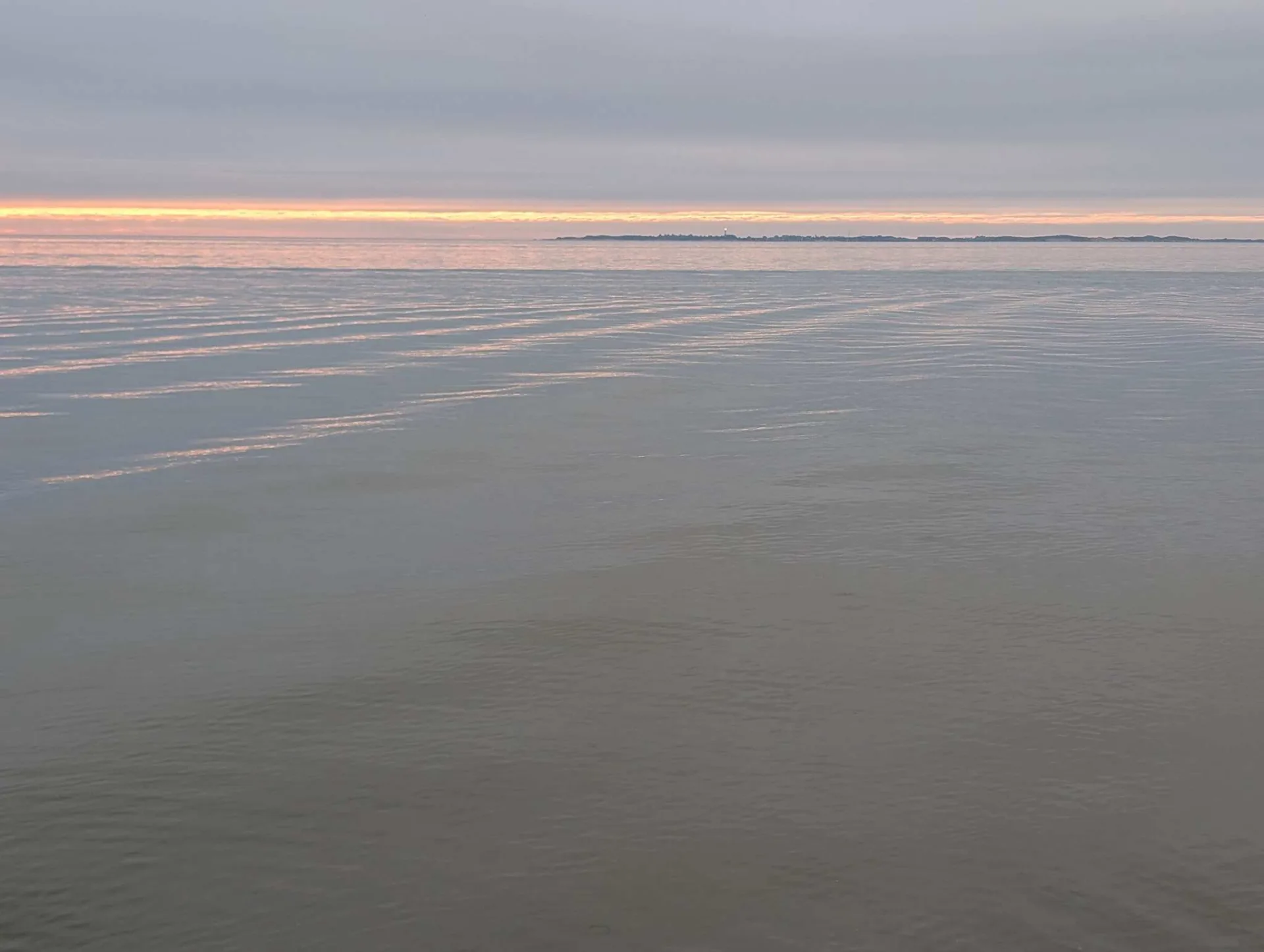 Evening over the mudflats: a thin band of light above Amrum, the rest a quiet grey.
