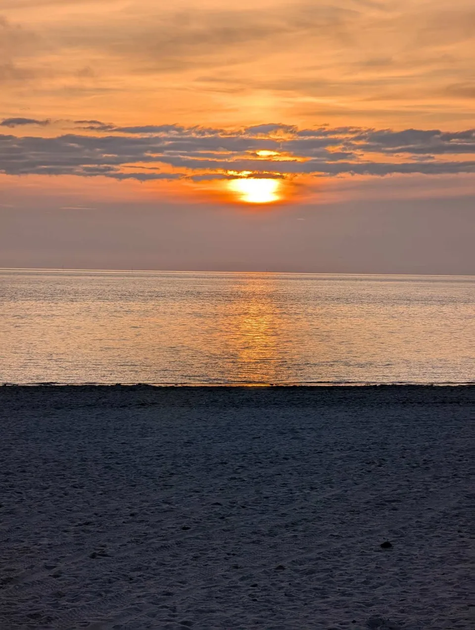 Sunset over the Wadden Sea, the beach already in shadow.
