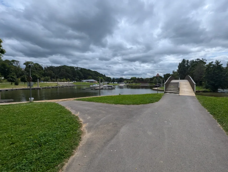 At the marina, an arched wooden bridge crosses the Meuse.