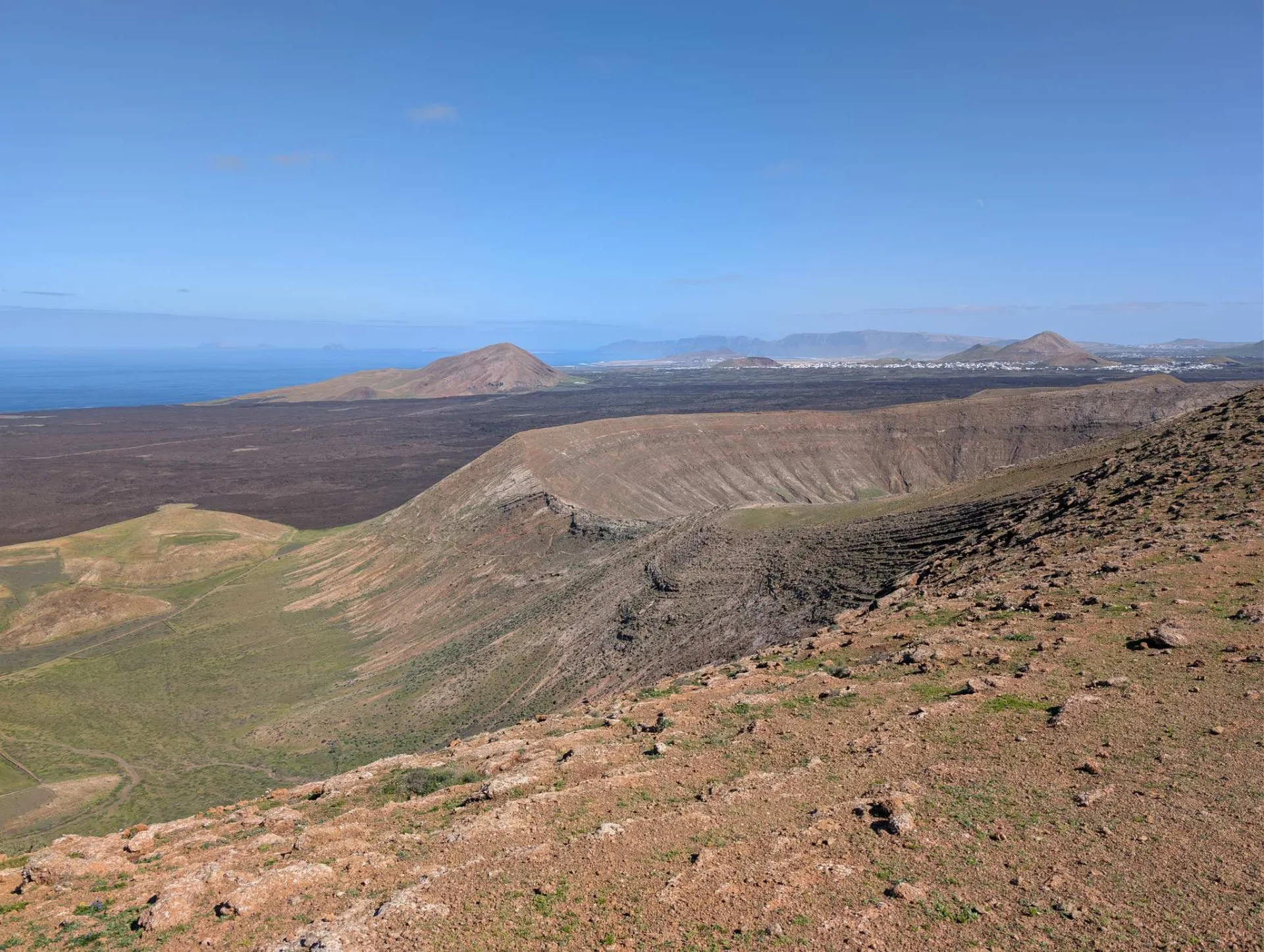 From the crater rim, the view over the volcanic field to the sea.