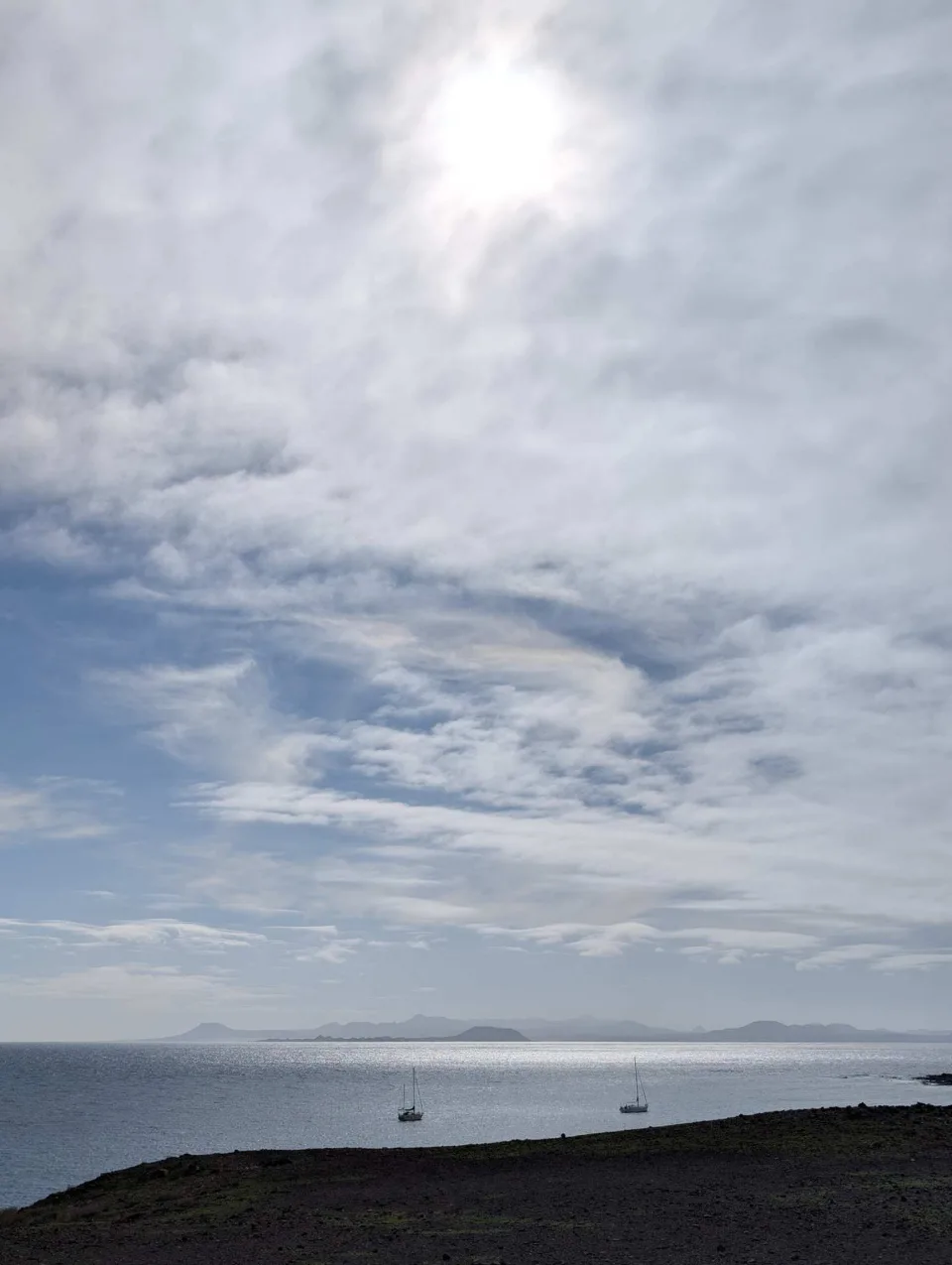 A wide, almost empty sandy beach under an overcast sky.