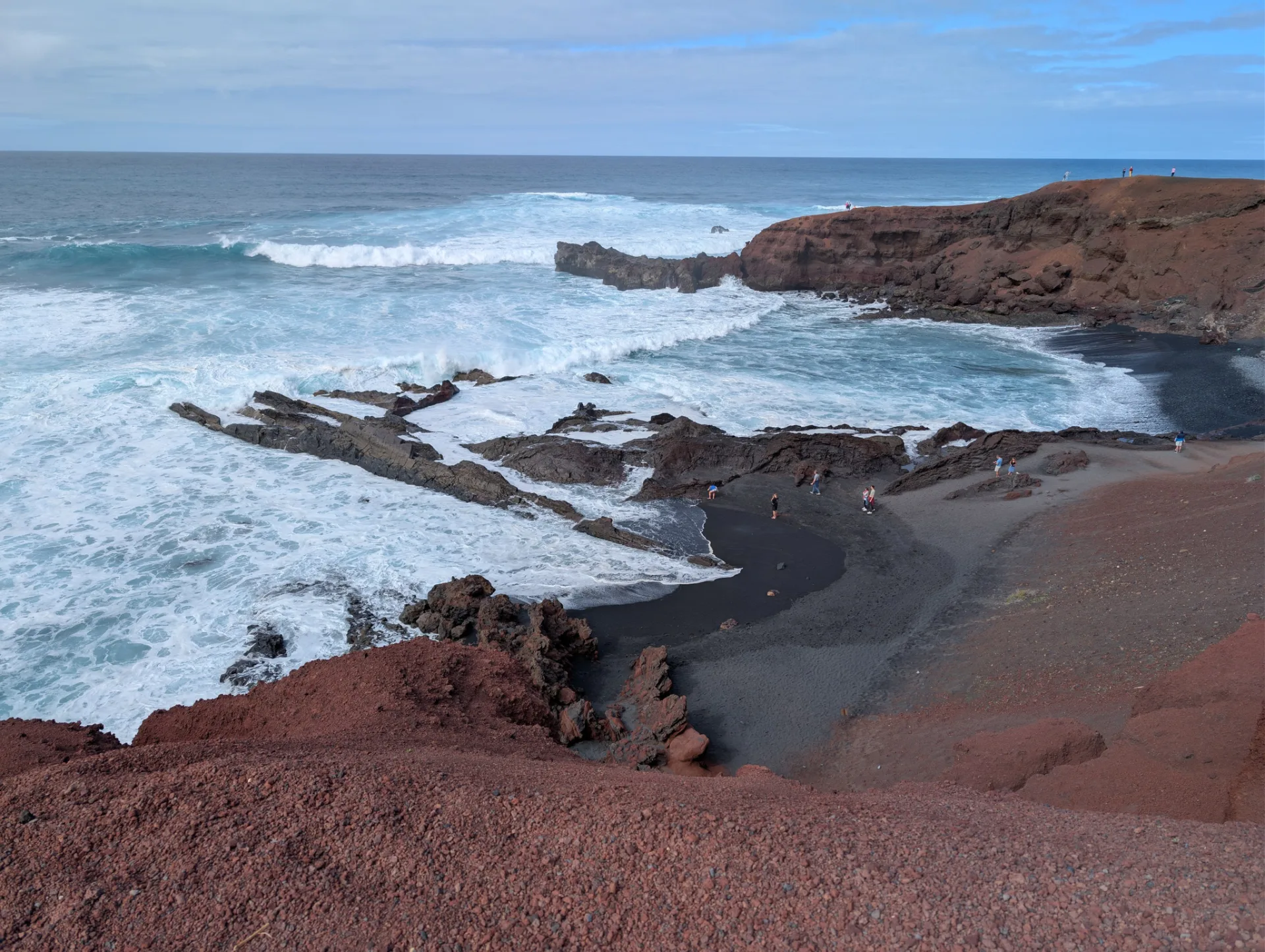 Red tuff cliffs and surf on the coast at El Golfo.