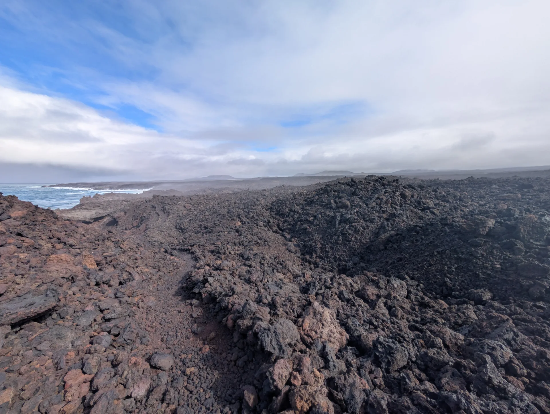 An endless field of jagged block lava runs to the sea.