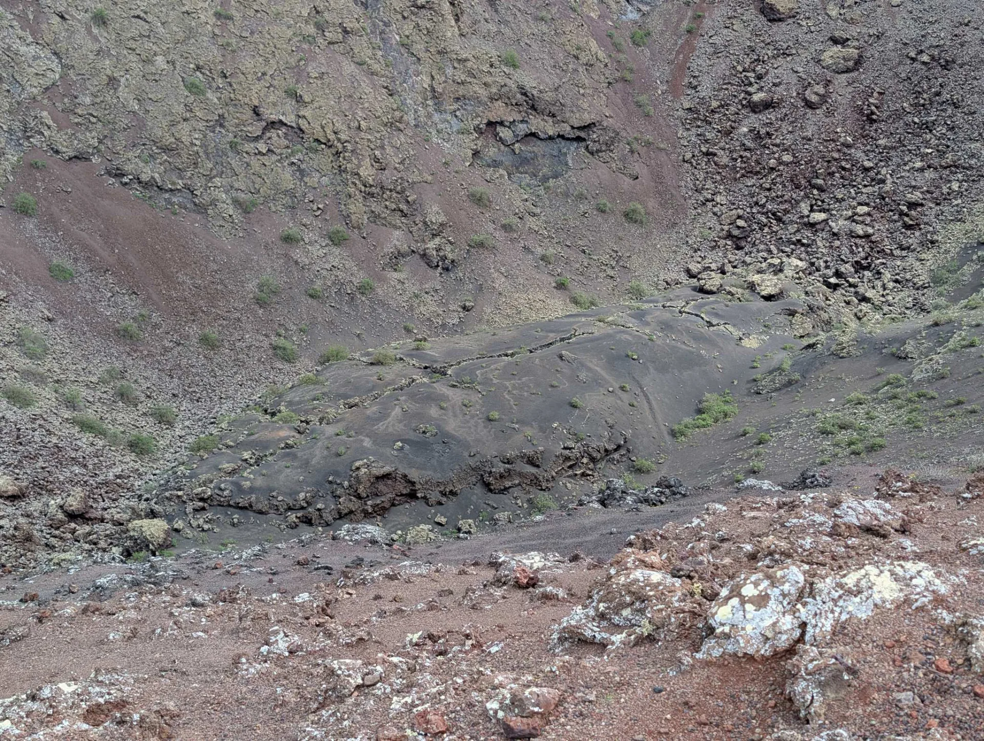 Looking into the wide, earth-toned bowl of the crater.