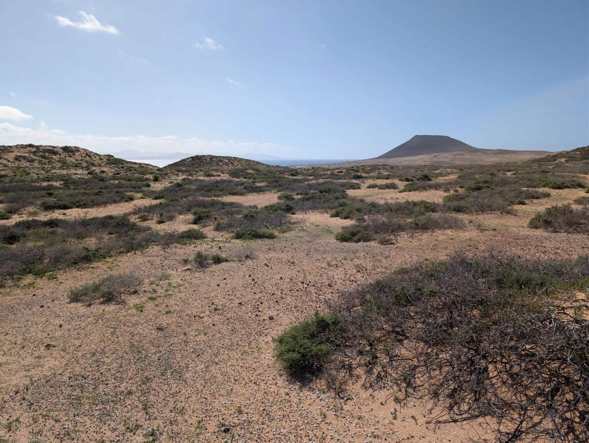 A wide plain with a distant volcanic cone on the neighbouring island.