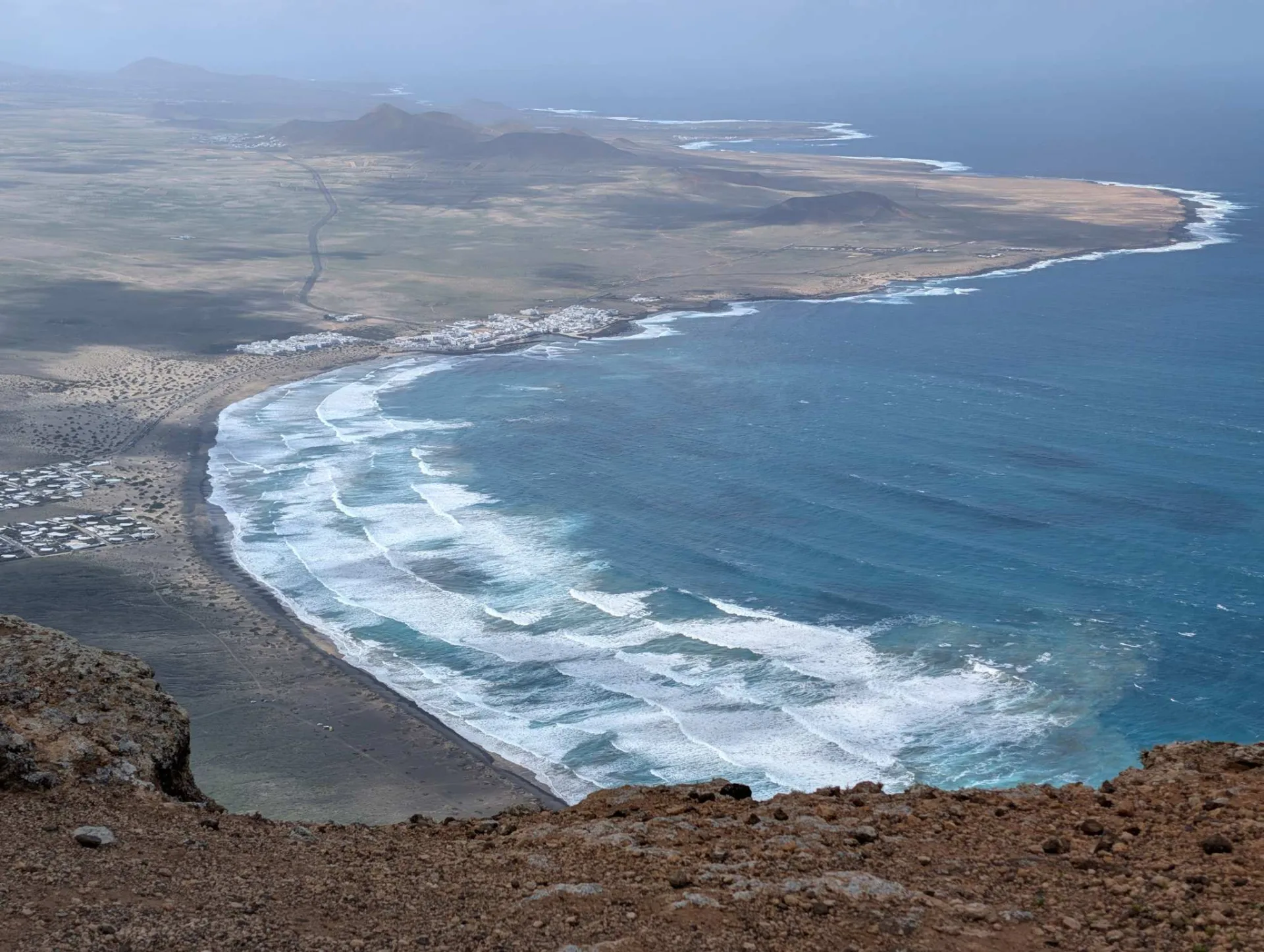 The wide sweep of Playa de Famara, far below the cliffs.