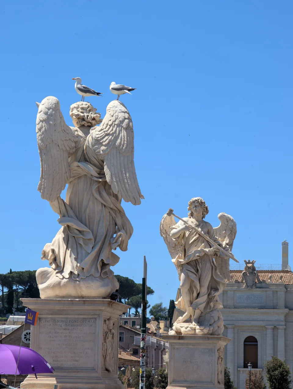 Two angel statues on the Ponte Sant'Angelo, gulls on top