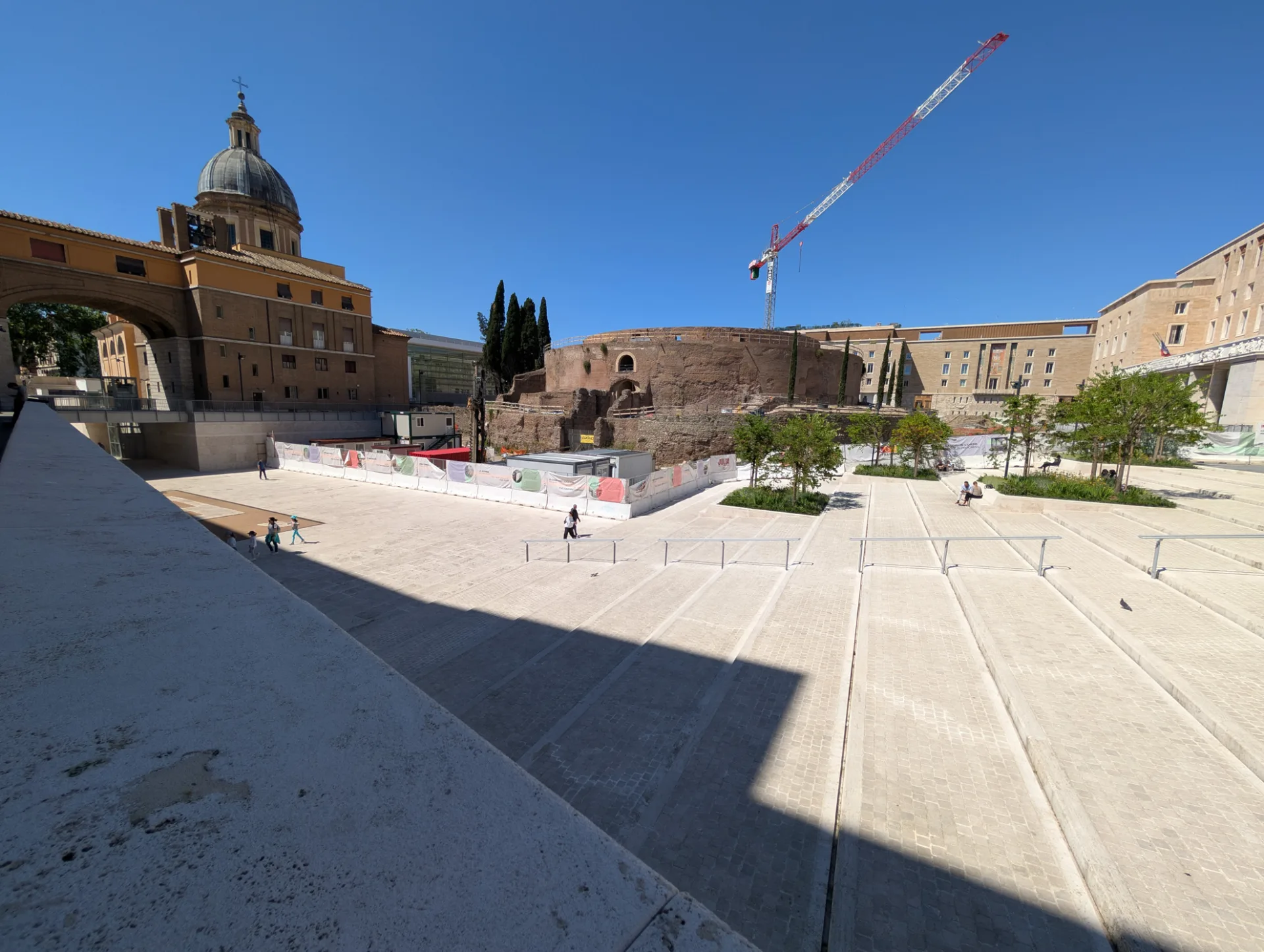Square in front of San Rocco — dome, ancient rotunda and a construction crane side by side