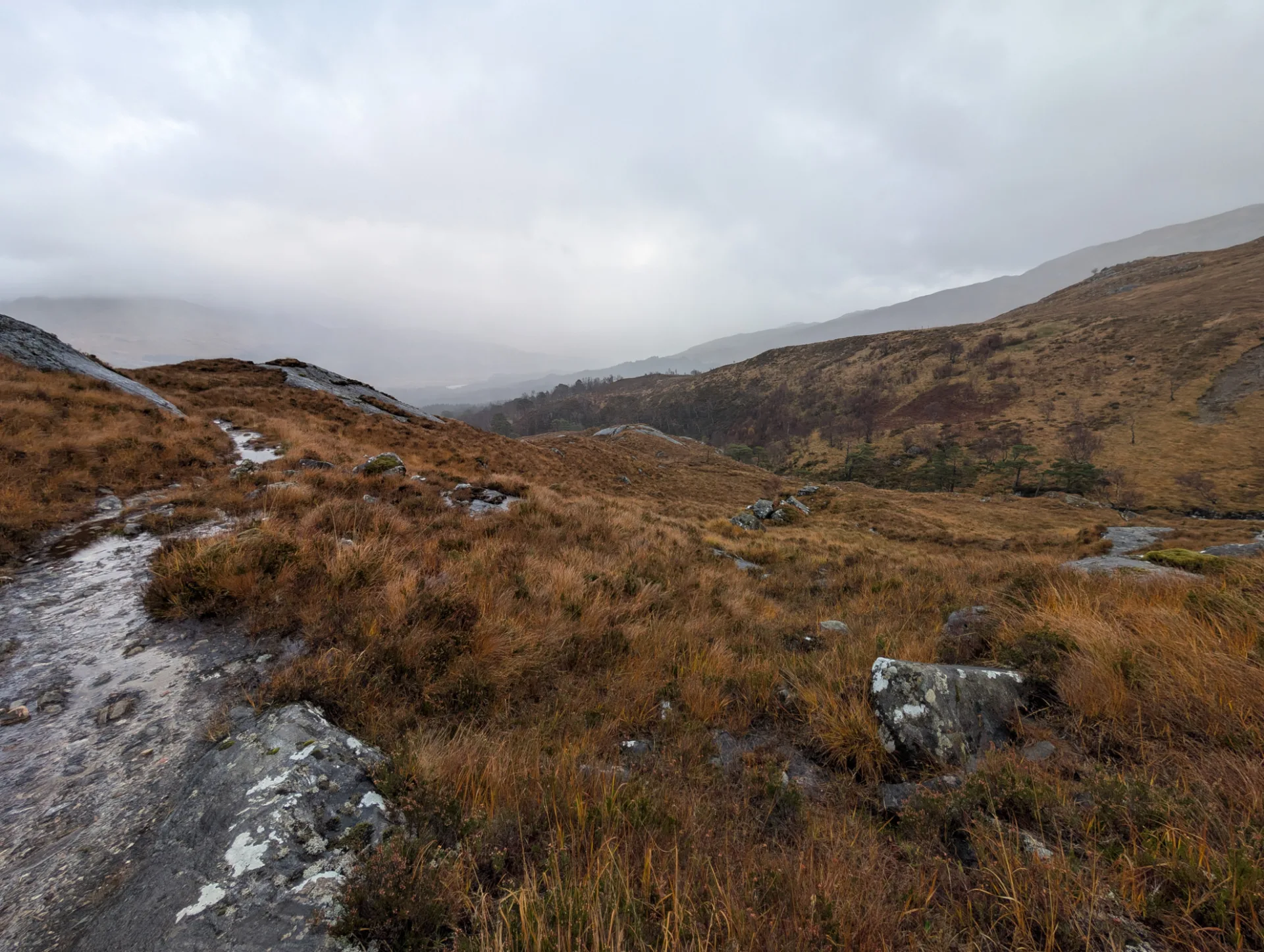 Path between rocks, a wide view down the valley — back down towards Glenfinnan