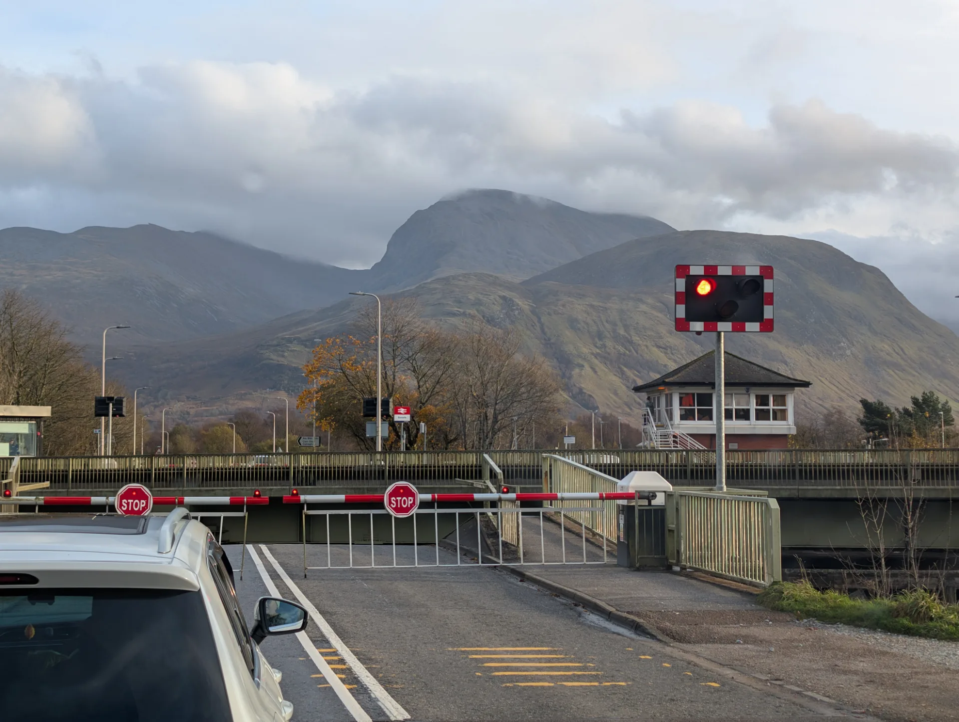 Level crossing near Fort William, Ben Nevis behind — back in civilisation